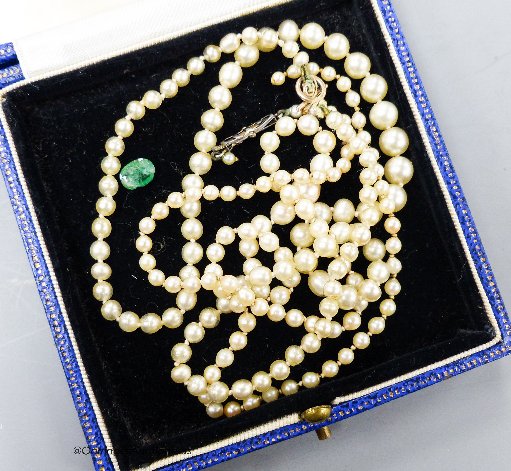 A single strand graduated cultured pearl necklace, 46cm, a simulated pearl necklace and an unmounted oval cut gemstone.